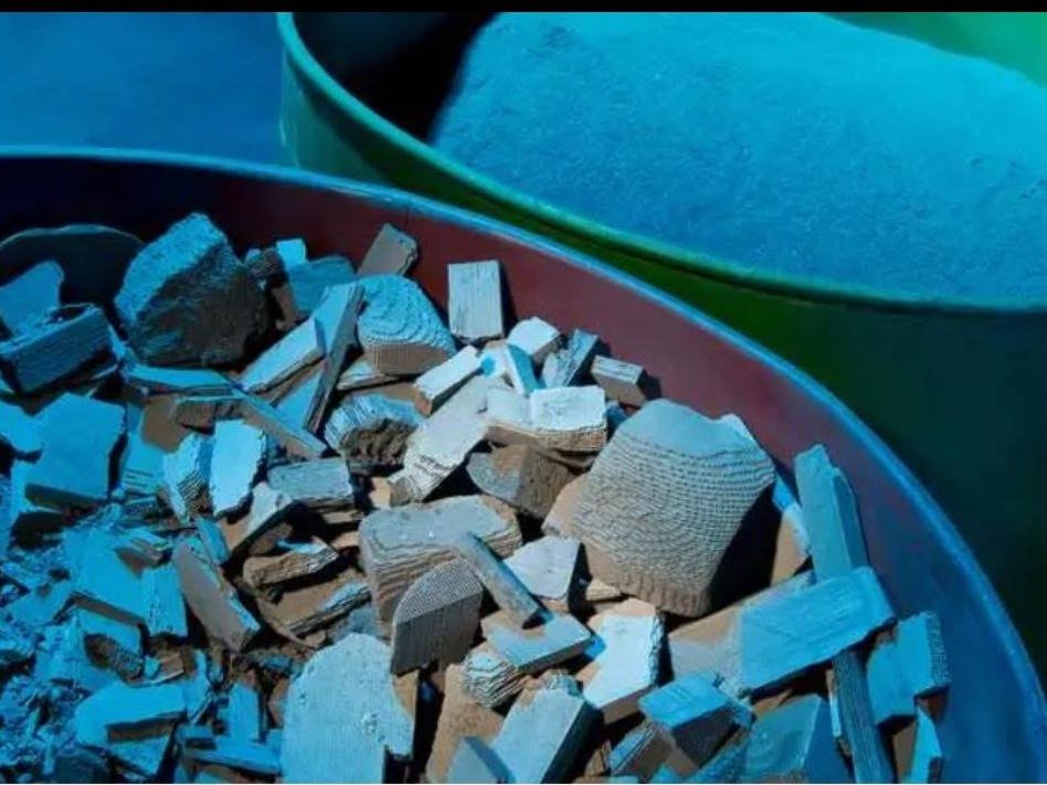 Milled catalyst substrate and the recovered powder alongside it in processing drums